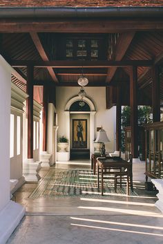 the inside of a house with an entrance way leading to another room that has a table and chairs in it