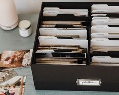 an open file cabinet filled with files on top of a table