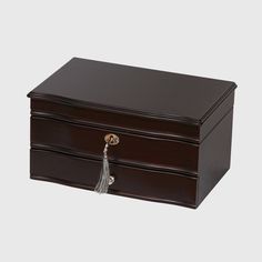 a brown wooden jewelry box with tassels