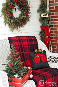 christmas decorations on the front porch with red and black plaid pillows, wreaths and other holiday decor