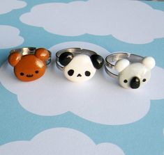 three rings with panda bears on them sitting on a blue and white tableclothed surface