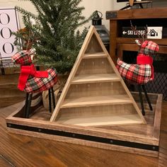 a wooden christmas tree with red plaid bows on it and two deer figurines