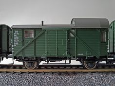 a green train car sitting on the tracks