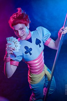 a woman with red hair holding a stick and playing cards