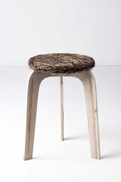 a stool made out of wood with a woven seat cover on it's back