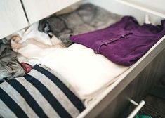 an open drawer with clothes in it