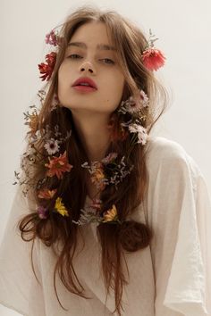 a woman with flowers in her hair wearing a white shirt and flowered neck tie