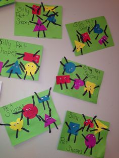 children's handprinted cards with different colored bugs on green and yellow paper