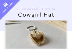 a crocheted keychain with the words cowgirl hat written in black