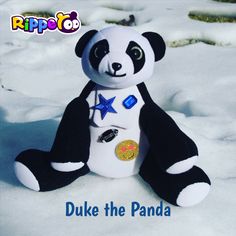 a stuffed panda bear sitting in the snow with its star on it's chest