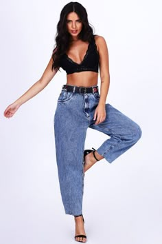 a woman posing for the camera wearing high waist jeans and a crop top with black straps