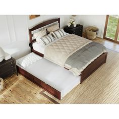 a large bed sitting on top of a hard wood floor next to a wooden dresser