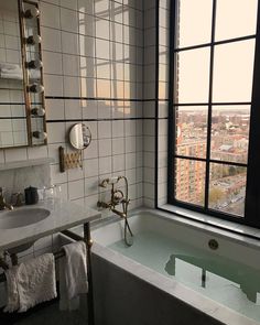 a bath tub sitting next to a window in a bathroom