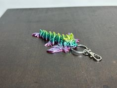 East Coast 3D is now offering 3D Printed Articulated Keychains in a couple different styles and colors to add some aesthetics to your bag or anything you can clip your keychain on. All of the Flexi Keychains move freely. The tiny wyvern has movable parts in the tail, wings and head. Printed in 100% made of environment-friendly natural materials, harmless to users and the environment. The designs are brought to you by Cinderwing3d. These flexis have the ability to be broken if put under high stre Fourth Wing Dragons, Bird Watching Gifts, Gothic Dragon, Cute Keychains, Dragon 3d, Frog Gifts, Crystal Dragon, Fourth Wing, Polymer Earrings