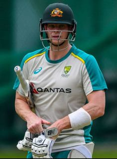 a man holding a cricket bat and wearing a helmet