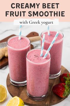 two glasses filled with fruit smoothie on top of a cutting board