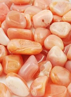 some pink and orange rocks on a white surface