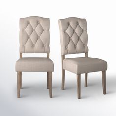 two beige chairs sitting side by side in front of a white background and one has a buttoned up back