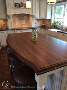 a kitchen with an island in the middle of it and white cabinets on both sides