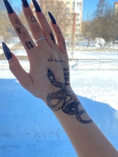 a woman's hand with some tattoos on it