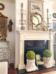 a living room filled with furniture and a fire place covered in green plants on top of a mantle