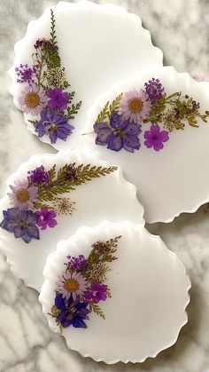 three white plates with purple flowers on them