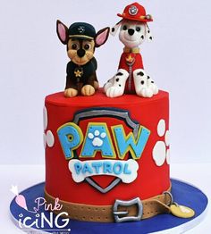 two dogs are sitting on top of a cake with paw patrol written on the side