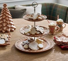 three tiered trays filled with cookies and pastries on top of a wooden table