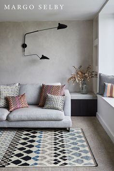 a living room with a gray couch and colorful pillows