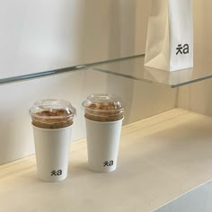 two cups of coffee sitting on top of a counter