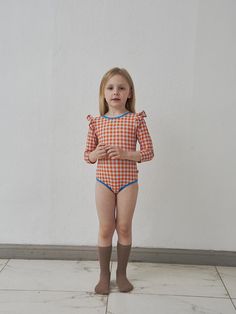 This Korean-made children's swimwear set includes a three-piece swim cap and one-piece swimsuit featuring a vibrant orange checkered pattern with blue contrast details. The set is crafted with UPF 50+ protection and moisture-wicking properties, while incorporating thoughtful design elements like front lining for temperature regulation and a hygiene sticker in the crotch area. Available in sizes XS through L for children aged 1-5 years, the suit combines functionality with style through its four- Kid Swimsuit, Kids Puff, Swimsuit Orange, Swim Cap, Orange Swimsuit, Checkered Dress, Swim Caps, Swimwear Sets, Kids Swimwear