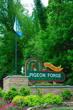 the sign for pigeonon force is in front of some trees and bushes with flowers