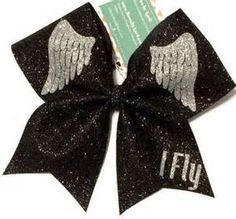 a black and silver hair bow with angel wings on it that says fly in white letters