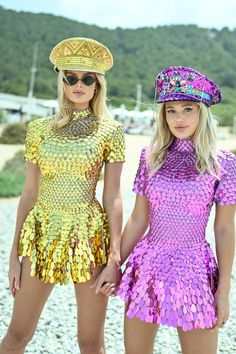 two beautiful women standing next to each other wearing hats and bodysuits with sequins on them