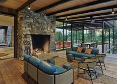 a living room filled with furniture and a fire place in front of a stone fireplace