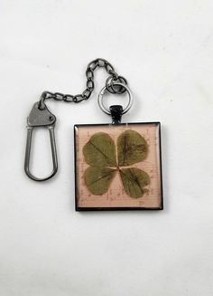 a key chain with a four leaf clover on it and a bottle opener hanging from the side