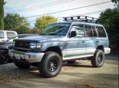 a silver suv parked next to another vehicle