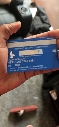 a person holding a blue business card in their hand