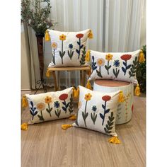 four pillows with flowers on them sitting on the floor