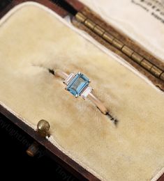 an antique blue topaz ring sits in its box