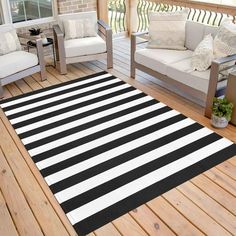 a black and white striped rug sitting on top of a wooden floor next to two couches