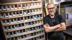 a man standing in front of a shelf filled with boxes