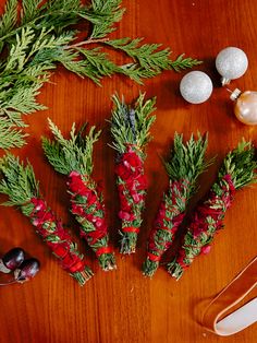 christmas decorations are laid out on a table with pine branches and other holiday decor items