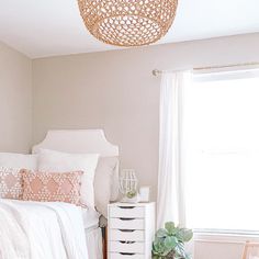 a bedroom with a bed, dresser and chair next to a window in the corner