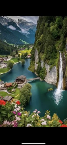 a scenic view of a mountain lake with a waterfall in the middle and houses on the other side