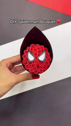 someone is holding up a paper flower box with an image of a spiderman on it