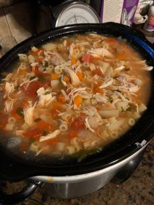 a pot filled with chicken noodle soup on top of a counter