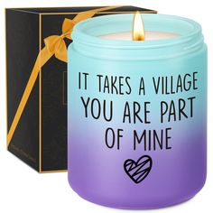 a candle that says it takes a village you are part of mine in front of a box