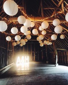 a barn with paper lanterns hanging from it's ceiling and the word aha underneath