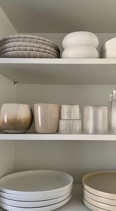 white dishes and plates on shelves in a kitchen